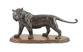 A large Japanese Meiji bronze model of a stalking tiger, Meiji period,Unsigned,58.5 cm long, wood