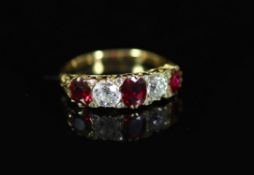 A Victorian style gold, three stone ruby and two stone diamond set half hoop ring,with carved