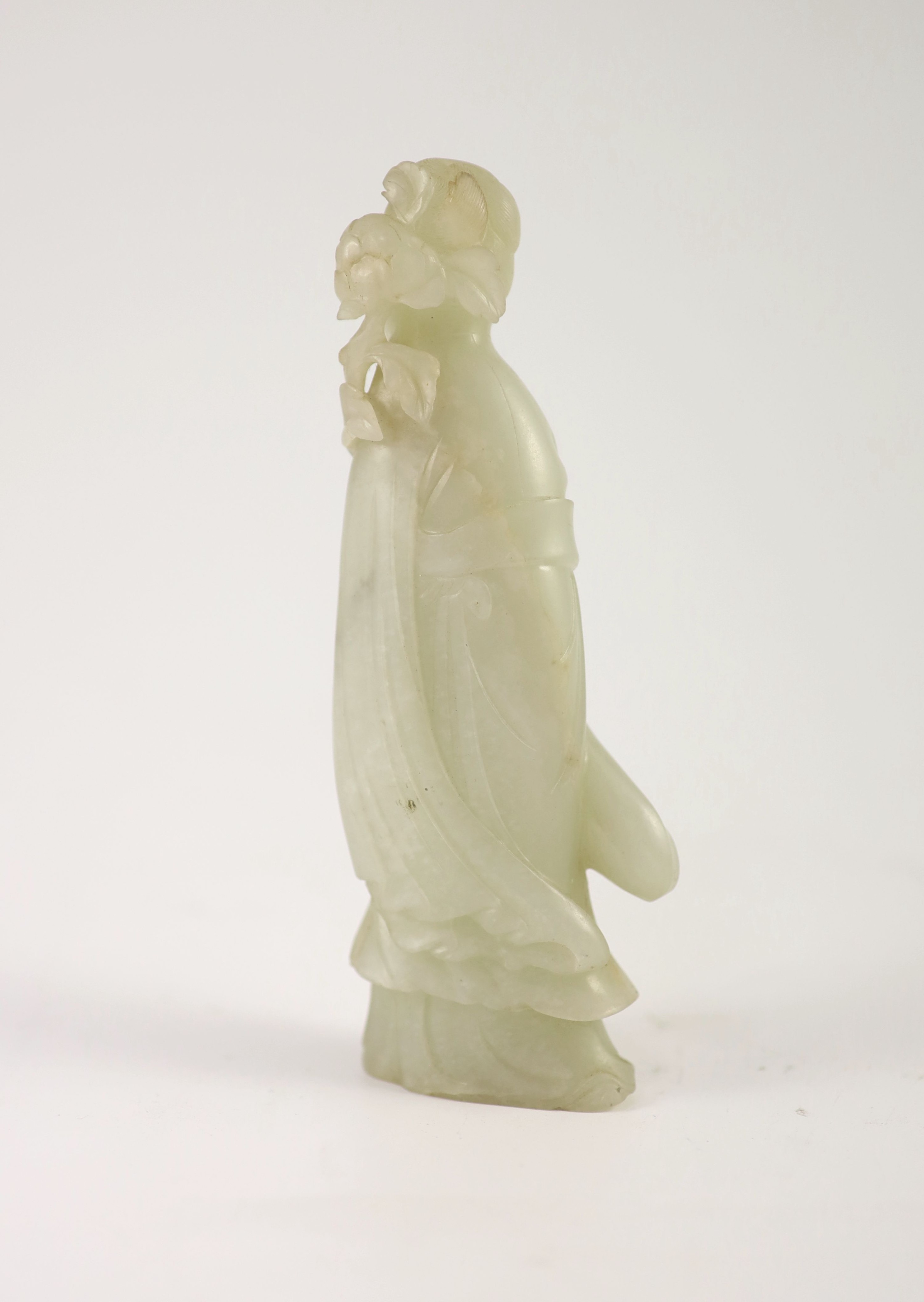 A Chinese pale celadon jade figure of a lady, 18th century,standing and holding a flower sprig, - Image 2 of 3