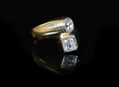 A Continental gold and collet set two stone diamond crossover ring,with a total diamond weight of