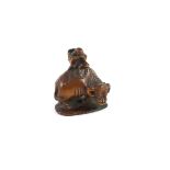 A Japanese boxwood netsuke of Semimaru playing the flute and riding upon an ox, School of