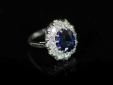 A modern 18ct white gold, sapphire and diamond set oval cluster ring, by Garrard & Co,size I,