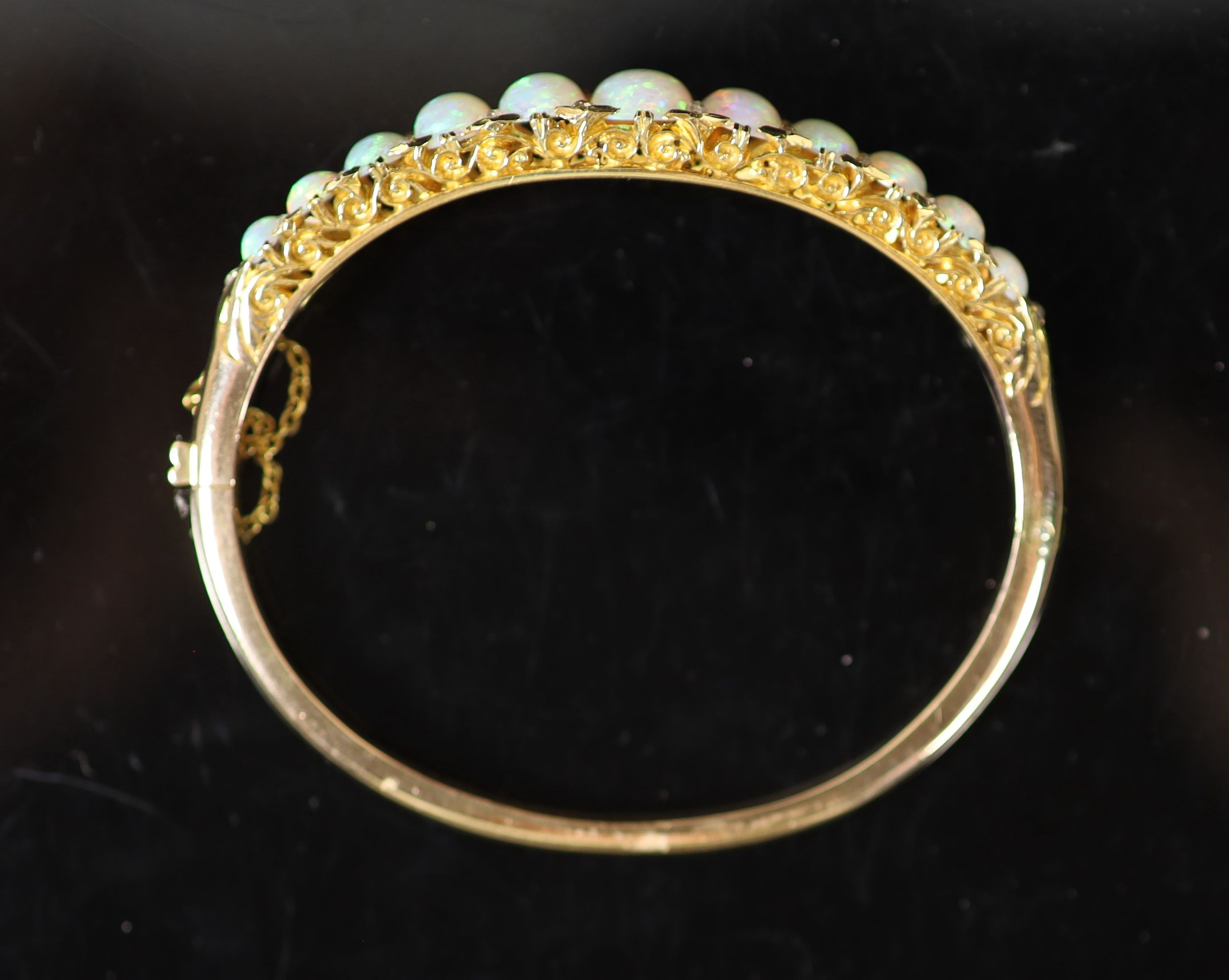 An Edwardian gold and graduated eleven stone white opal set hinged bracelet, with diamond chip - Image 2 of 3