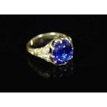 An 18ct gold and single stone claw set sapphire ring,with closed back setting and carved shoulders