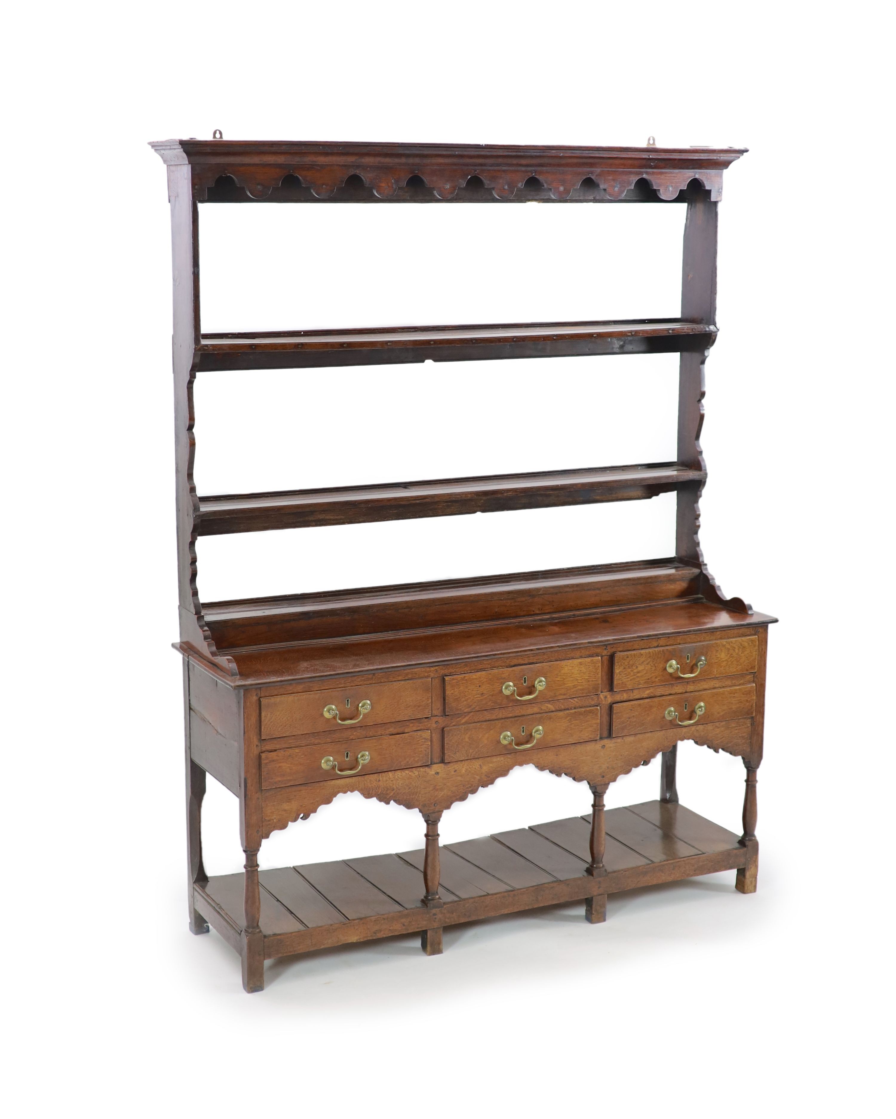A George III oak dresser,with two shelf rack and six long drawers over a pot board, on stile feet,