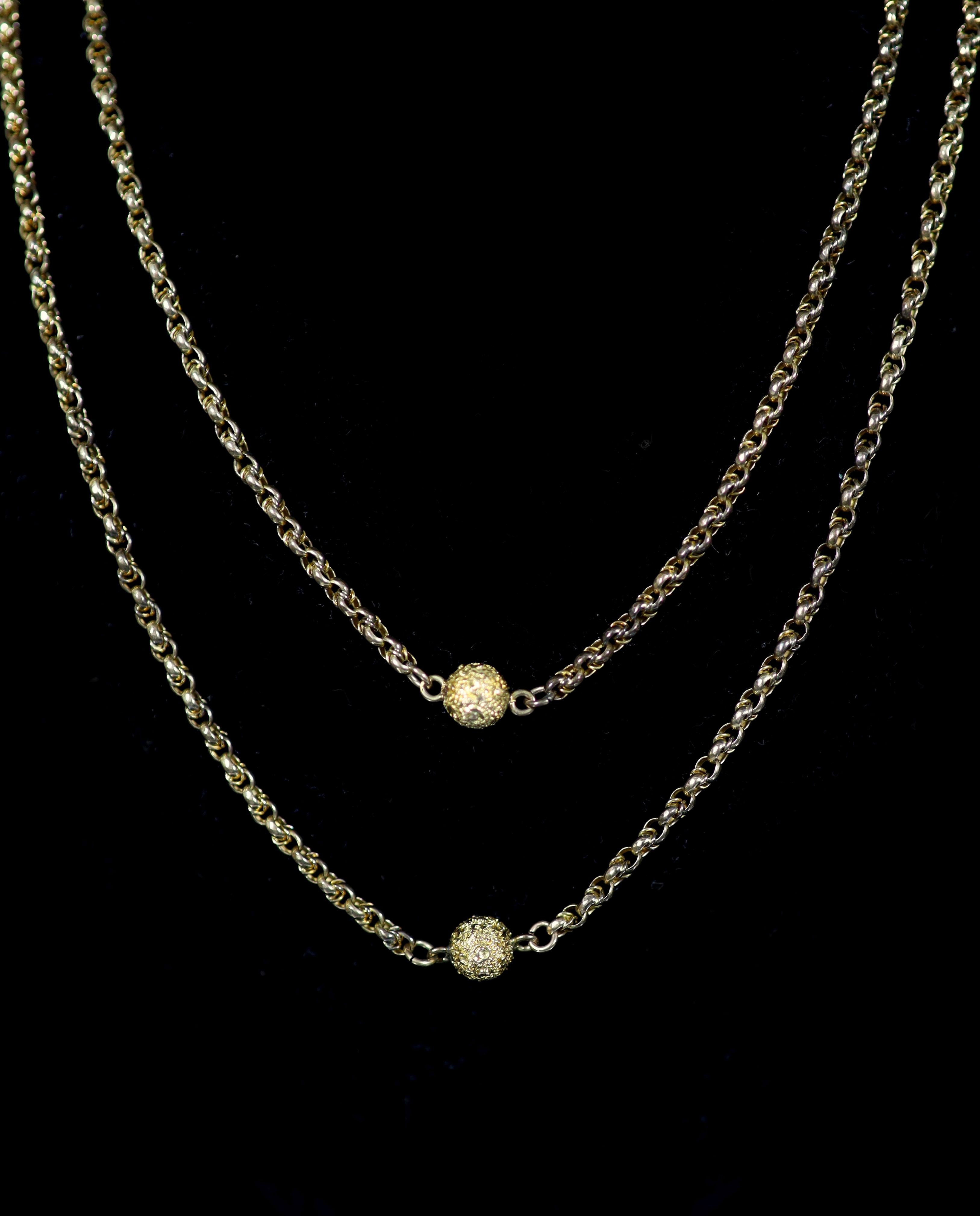 A 19th century 9ct gold guard chain with seven engraved spheres, 124cm,124cm, 27.2 grams.