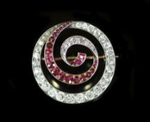 An early 20th century gold and silver, graduated ruby and diamond set open work whorl brooch,27mm,