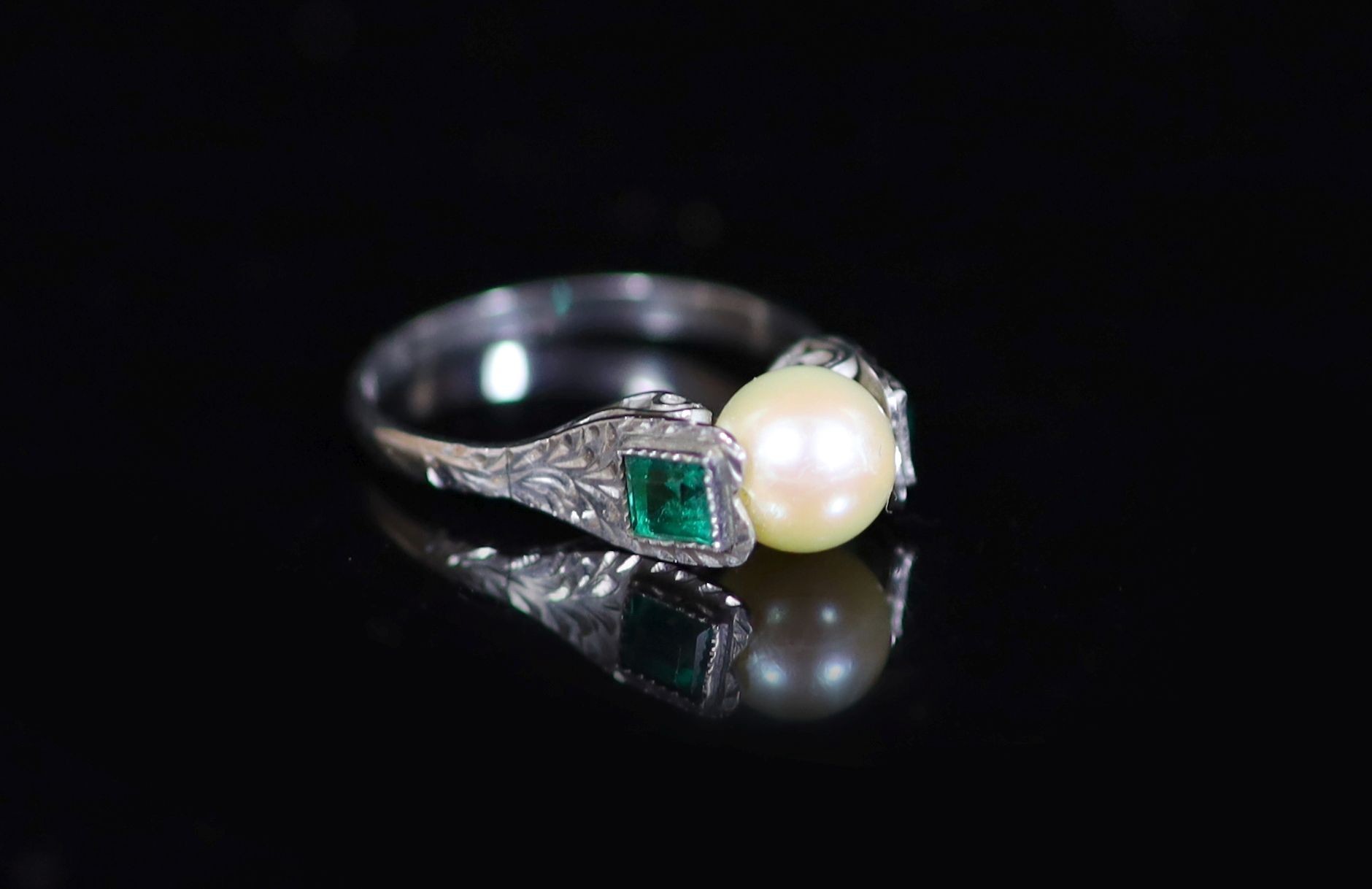 A mid 20th century white gold, cultured pearl and emerald set three stone ring,size N, gross 2