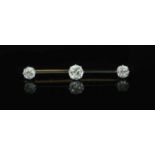 A gold, platinum and three stone diamond set bar brooch,45mm, gross weight 4.6 grams, the largest