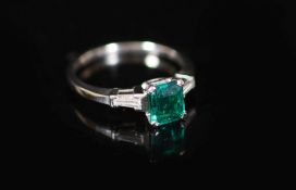 A platinum and single stone emerald ring with trapeze cut diamond set shoulders,size L/M, gross