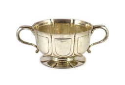 An Edwardian silver two handled pedestal fruit bowl, by William Comyns,with embossed panelled