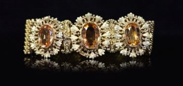 An early 19th century two colour gold and three stone oval cut topaz set bracelet,with mesh link