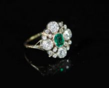 A 19th century gold and silver, emerald and diamond cluster dress ring,of oval form and set with