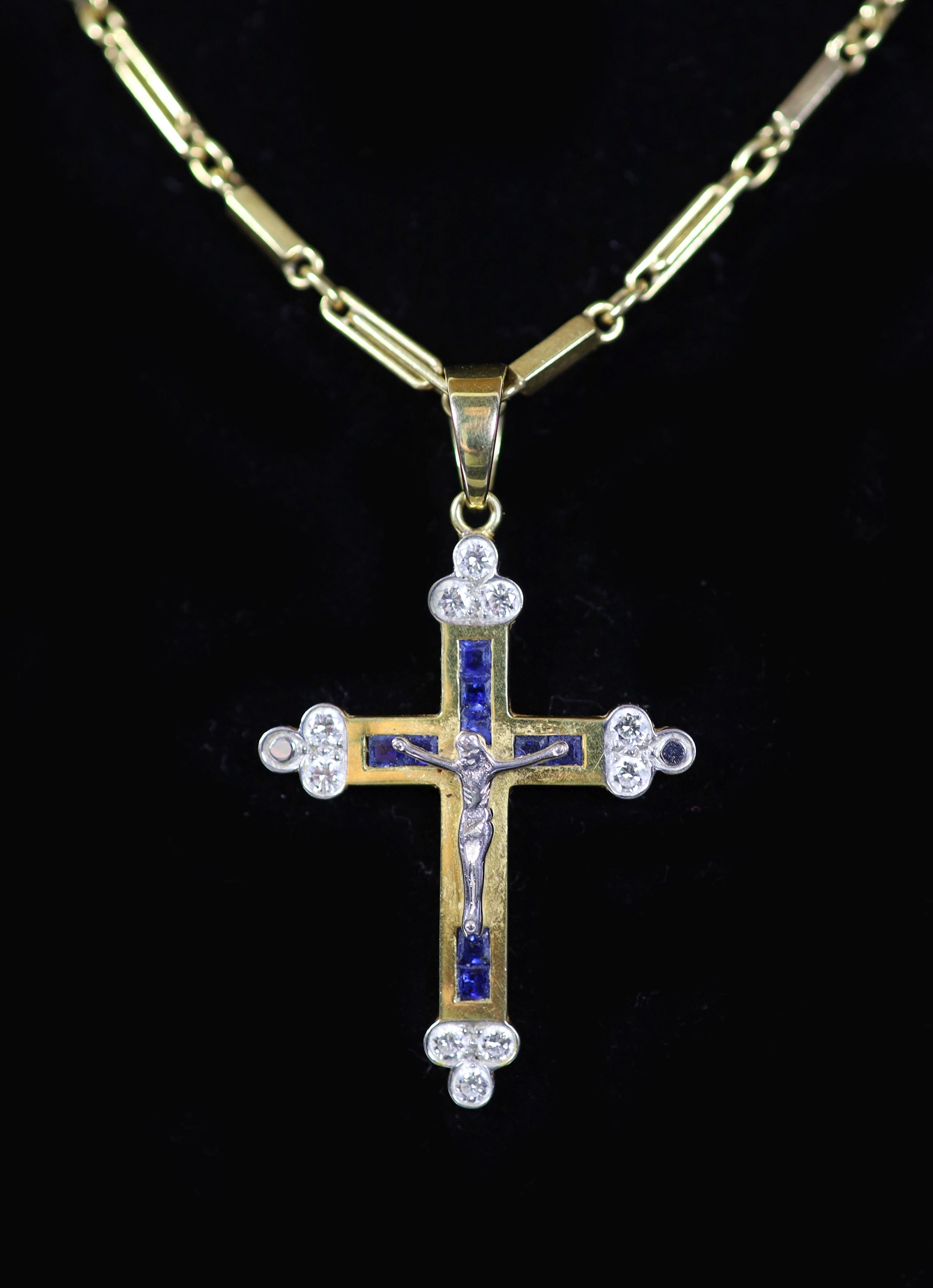 A modern 750 gold, sapphire and diamond set crucifix pendant, on a similar bar link chain,pendant