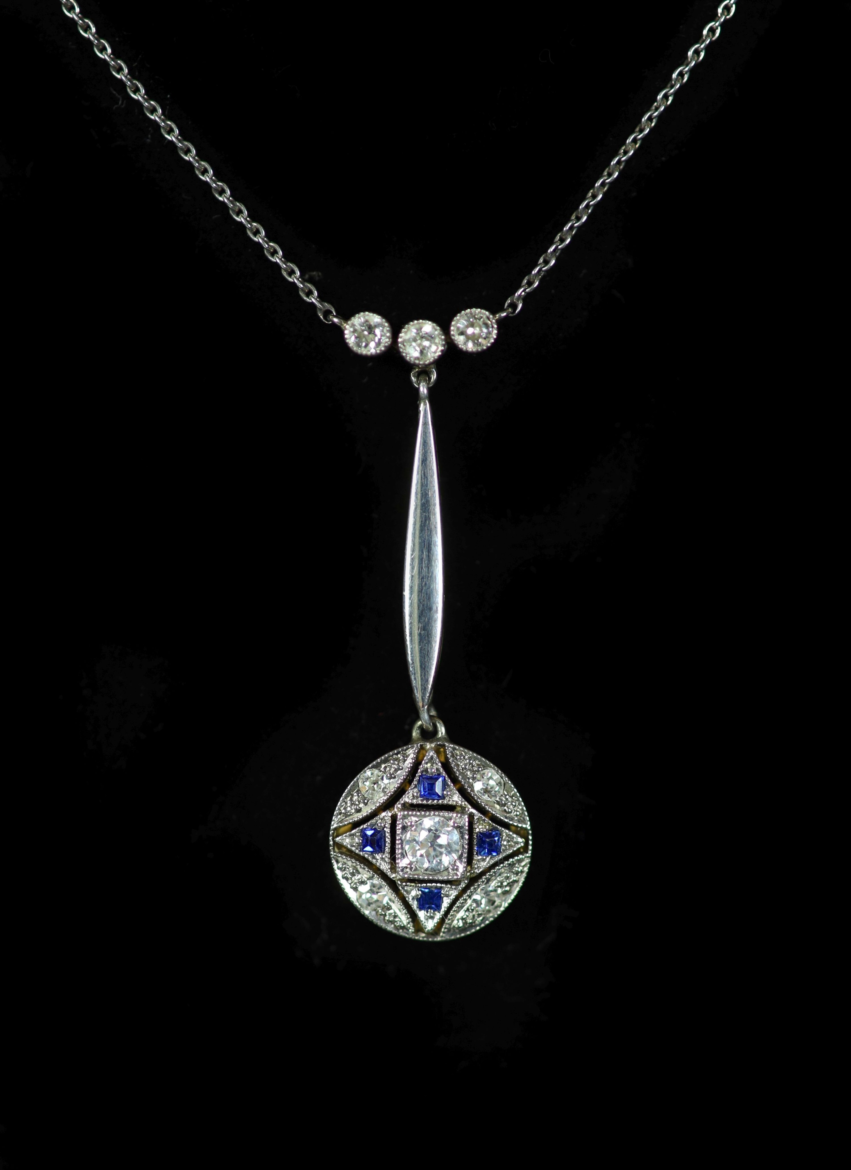 An Edwardian gold and platinum, millegrain set sapphire and diamond cluster set drop pendant