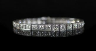 A mid 20th century engraved platinum and graduated old round cut diamond set line bracelet,set