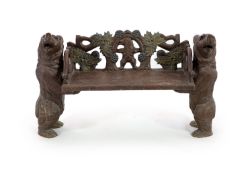 An early 20th century Black Forest carved wood bear hall seat,the vineous carved back centred with a