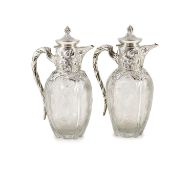 A good pair of late Victorian silver mounted ‘rock crystal’ glass claret jugs, with hinged covers,