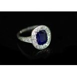 A 1930's platinum and gold, sapphire and diamond set oval cluster ring,the setting and shoulders