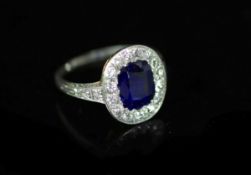 A 1930's platinum and gold, sapphire and diamond set oval cluster ring,the setting and shoulders