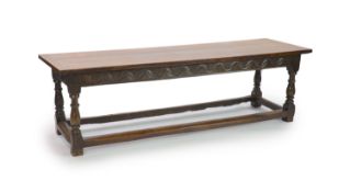 A William III oak refectory table, circa 1690,with cleated planked top, later carved frieze and