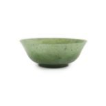 A Chinese spinach green jade bowl, 19th centuryof plain form with a slightly flared lip, on a