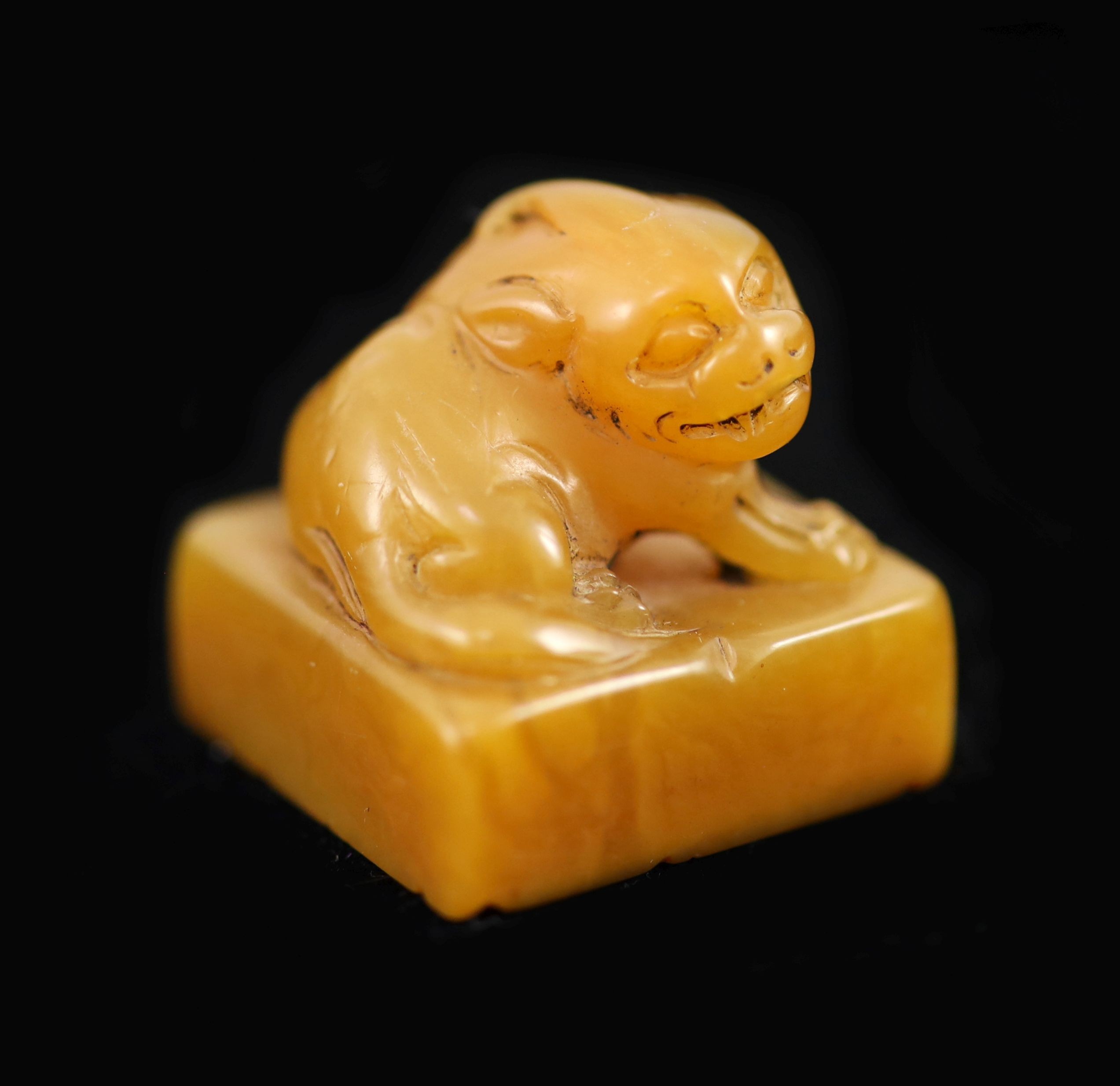 A Chinese tianhuang stone square seal,surmounted by a lion-dog, carved matrix,2.2 cm wide