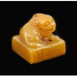 A Chinese tianhuang stone square seal,surmounted by a lion-dog, carved matrix,2.2 cm wide