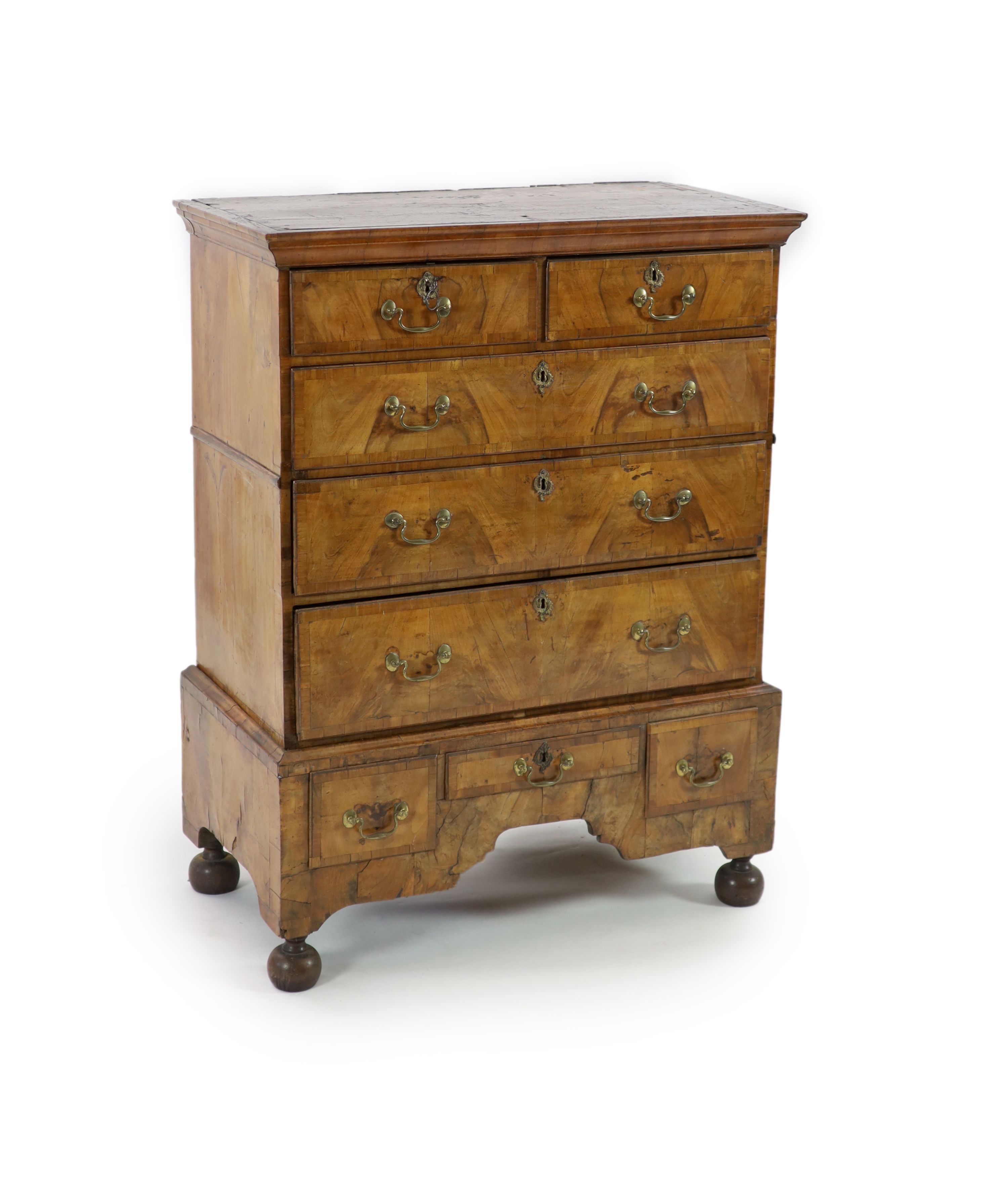 A George II walnut chest on standwith moulded cornice, two short and three graduated long drawers