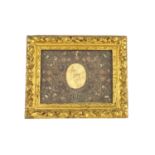 A 17th century wax papal sealnow presented in an 18th century paper scrollwork mount and gilt