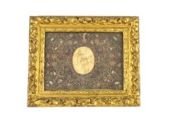 A 17th century wax papal sealnow presented in an 18th century paper scrollwork mount and gilt