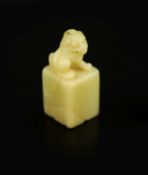 A Chinese inscribed cream coloured soapstone seal,of square section, surmounted by the figure of a