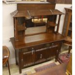 An early 20th century Arts & Crafts oak and polished steel mirrored sideboard, in the manner of