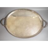 A late Victorian silver oval two handled tea tray, with gadrooned border and engraved inscription,