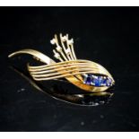 A modern yellow metal, sapphire and diamond set stylised spray brooch, 53mm, gross 9.7 grams.