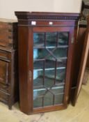A George III and later mahogany astragal glazed hanging corner cabinet, width 77cm, depth 50cm,