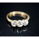 A yellow metal and three stone diamond ring, size M, gross 1.9 grams.