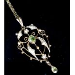 An Edwardian 9ct, peridot and seed pearl set drop pendant, 42mm, on a 9ct chain, 49cm,gross weight