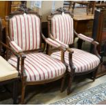 A pair of 19th century French carved walnut elbow chairs, width 61cm, depth 58cm, height 96cm