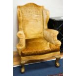 A Chippendale style gold velvet wing backed chair