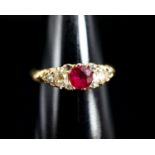An Edwardian 18ct gold, ruby and diamond three stone ring, with diamond chip spacers (one