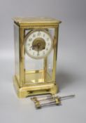 A French brass four glass clock, key and pendulum 27cm