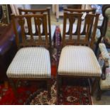 A set of four Art Nouveau carved oak dining chairs