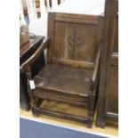 A joined oak merchant’s wainscot box-seated chair, the twin panelled back carved with a stylised