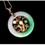 A yellow metal and gem set mounted jade disc pendant, 30mm on s yellow metal fine link chain,