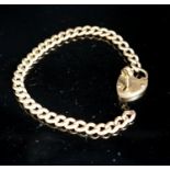 A yellow metal curb link bracelet with heart shaped clasp, with key, 20cm including clasp,10.8