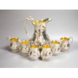 A good set of six Garrard & Co Ltd silver mugs and a matching jug, London, 1997, all embossed with