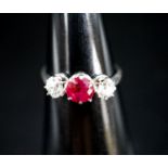 A white metal single stone ruby and two stone diamond ring, size L/M, gross weight 3 grams.