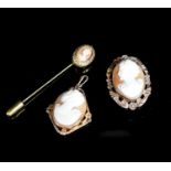 Two mounted cameo shell pendants, one with brooch attachment and a gilt metal cameo pin.