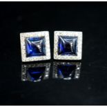A pair of white metal and blue cabochon set square ear studs with diamond set borders, 11mm, gross
